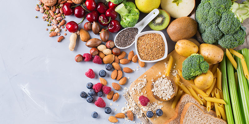 Fruits, vegetables, seeds and nuts spread out on a table.
