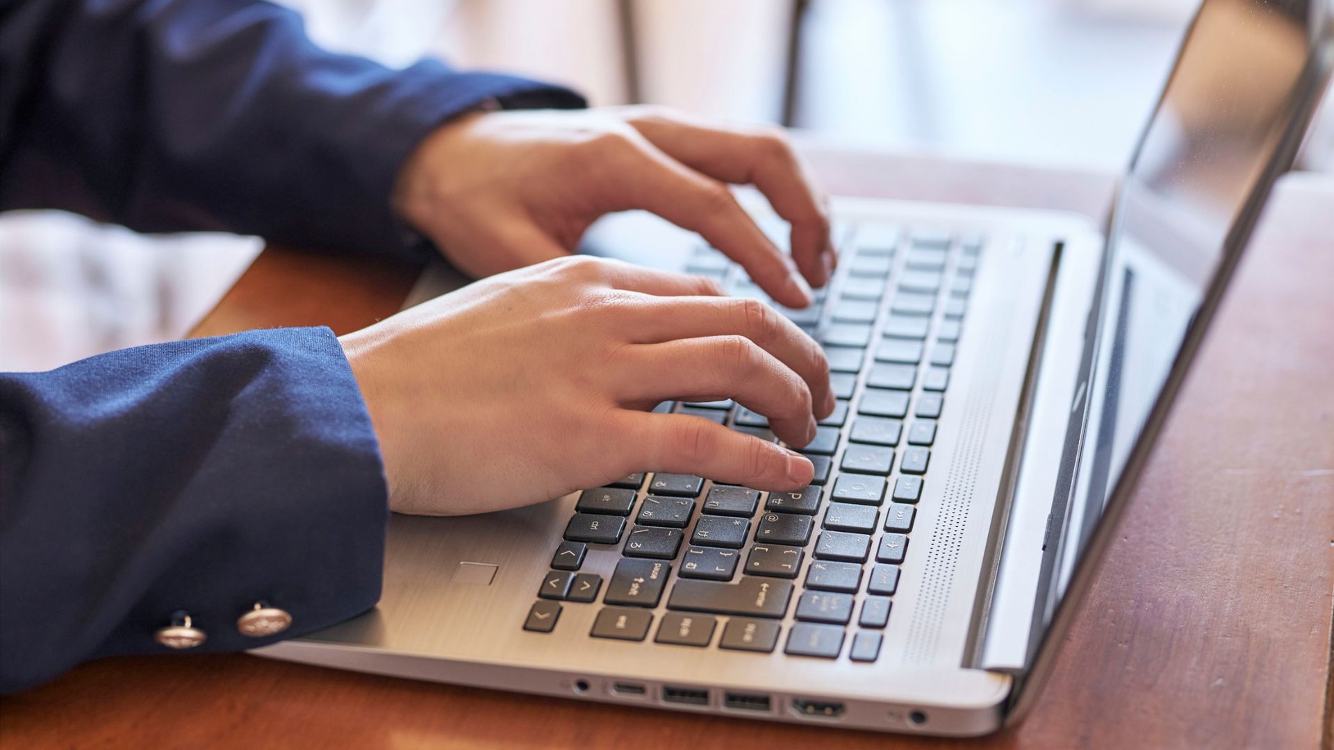 person typing on keyboard writing letter