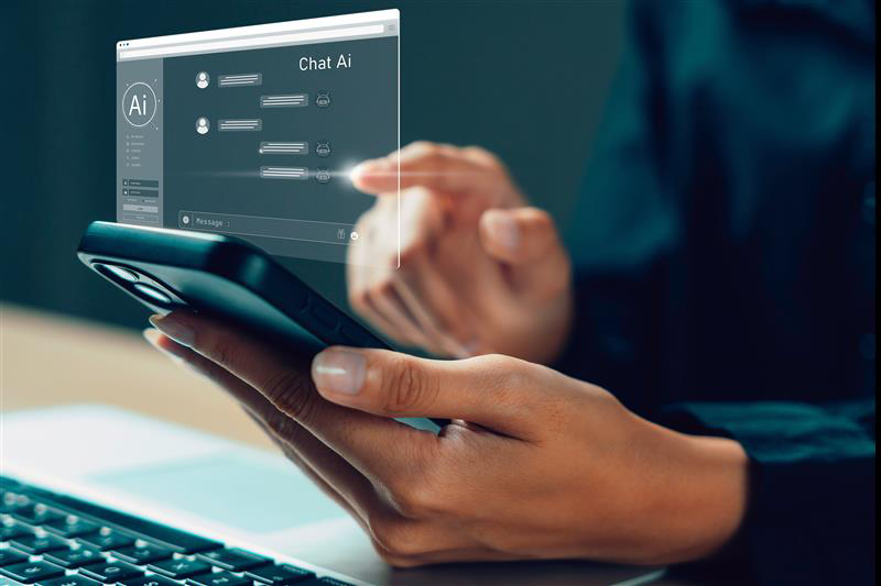 Close-up of a person's hands holding a smart phone and communicating with an AI chatbot.