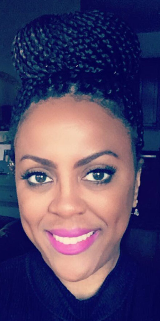 Kristen Harris, a black woman with dark, braided hair, large brown eyes, and bright pink lipstick.