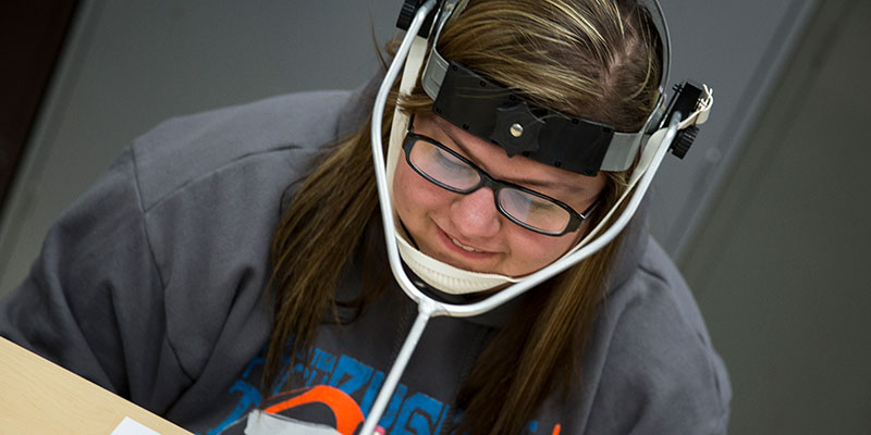Student wearing an assistive device for writing