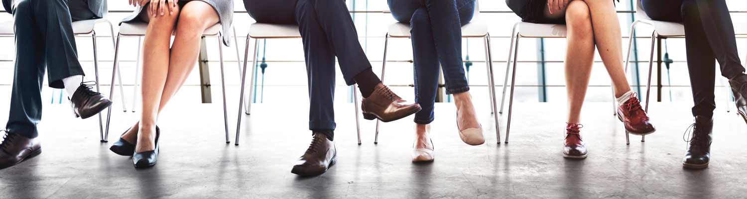 professionally dressed people sitting in chairs