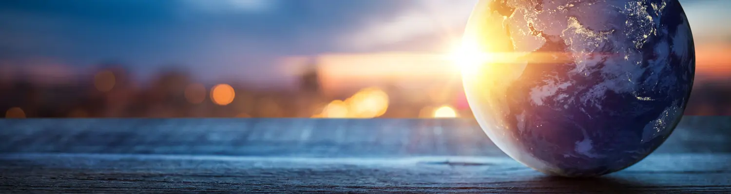 globe on table with sunrise/sunset in background