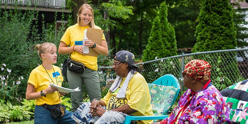 Two students engaging with community members during their internship.