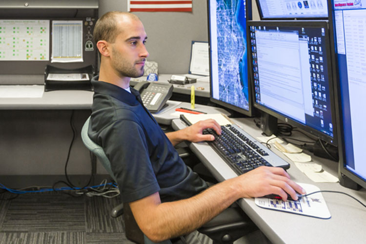 Portrait of Garret Knuth (white man), graduate of the Criminal Justice and Criminology program working at a computer