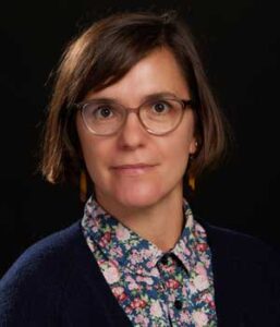 Professional headshot of Social Work Assistant Professor Jane Hereth (white woman), wearing a flowered shirt with a blue cardigan.