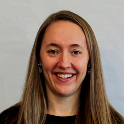 Headshot of a female alum wearing earrings and a black top.