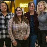 Student Social Work Association at UW-Milwaukee shows four women standing in the student union.