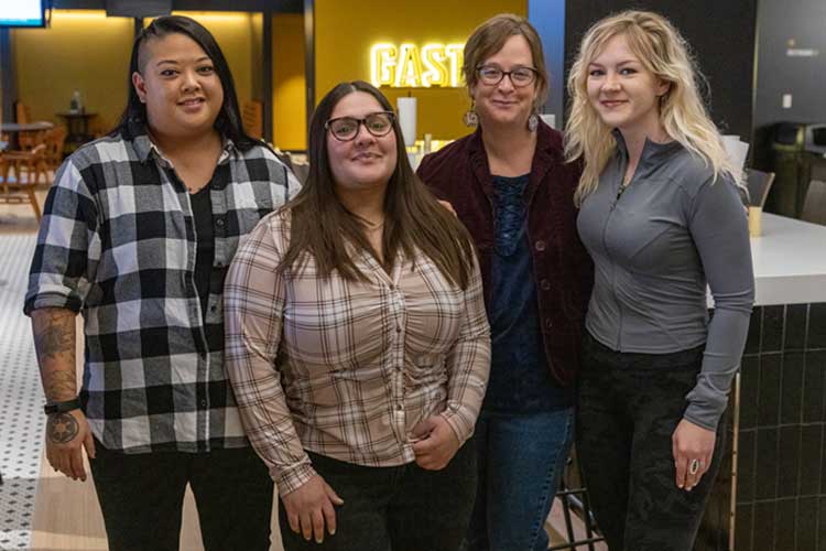 Student Social Work Association at UW-Milwaukee shows four women standing in the student union.