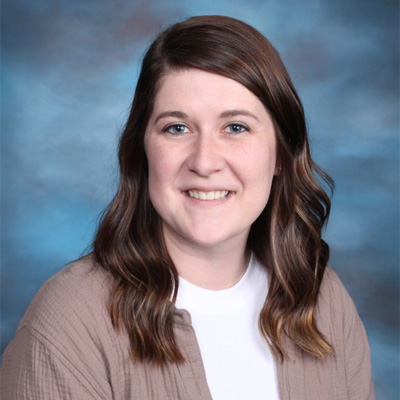 Professional headshot of white female school social worker wearing a beige jacket and white shirt.