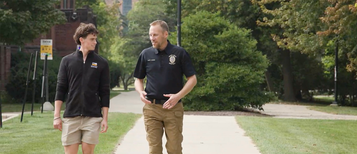 Carter Jenson, a UWM criminal justice student, walking on campus with an instructor