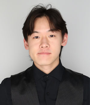 Headshot of Asian male wearing black shirt and vest.