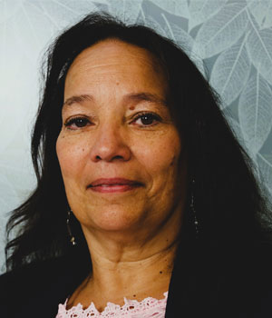 Headshot of multi-ethnic woman with a light blue background.