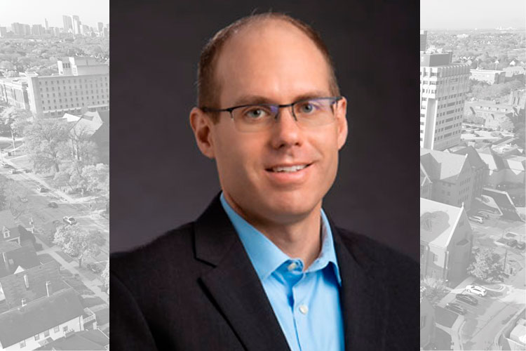 Social Work Assistant Professor Andrew Steward with a black and white aerial shot of the UWM campus in the background.
