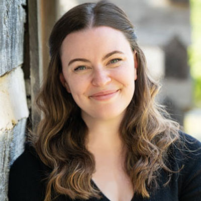Criminal Justice & Criminology Teaching Faculty Elizabeth Lyne leaning against a wall outside.