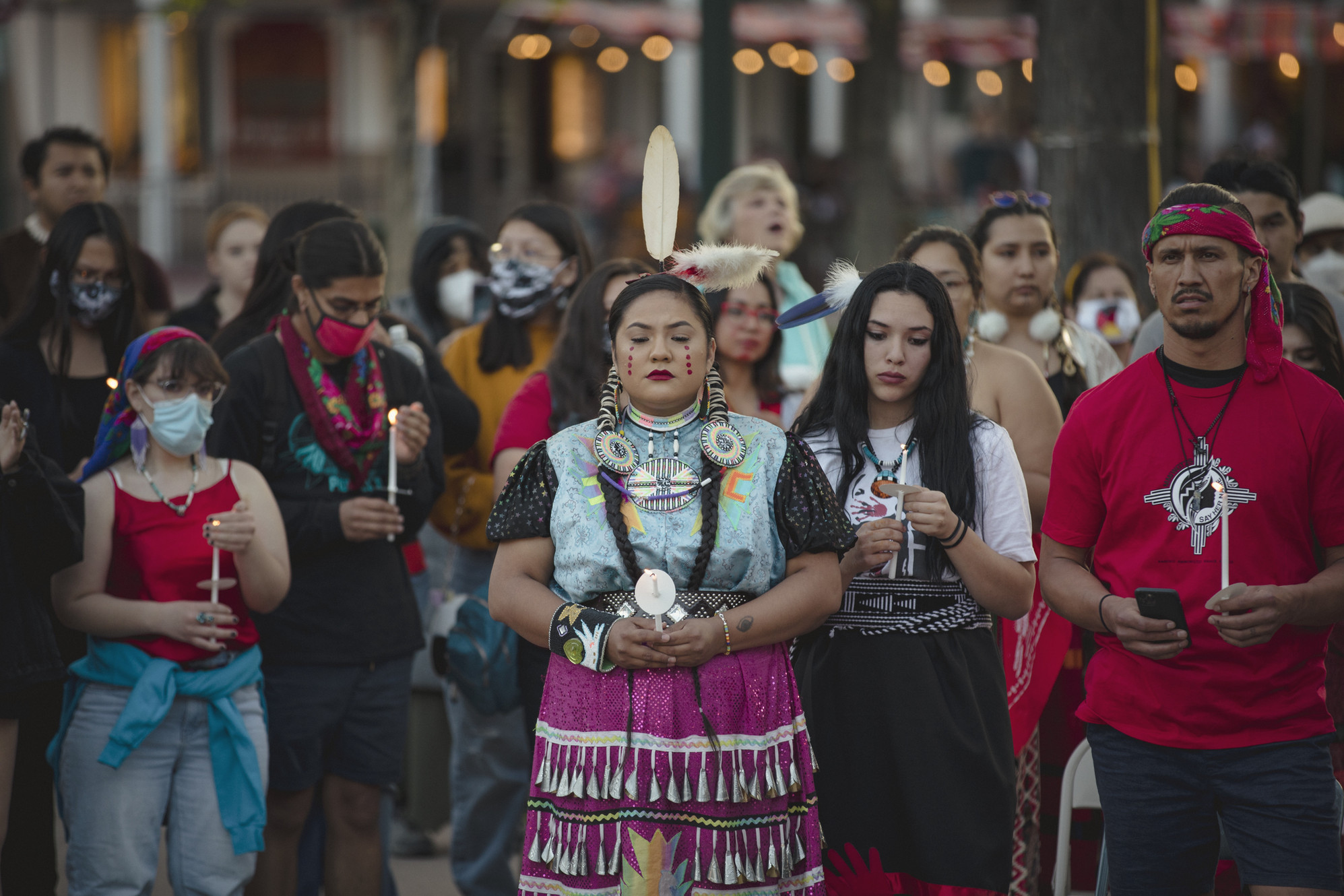 Photo from the documentary "She Cried That Day" A large group of indigenous people, some dressed in traditional garb and modern attire, stand facing the camera. It appears they are holding a vigil