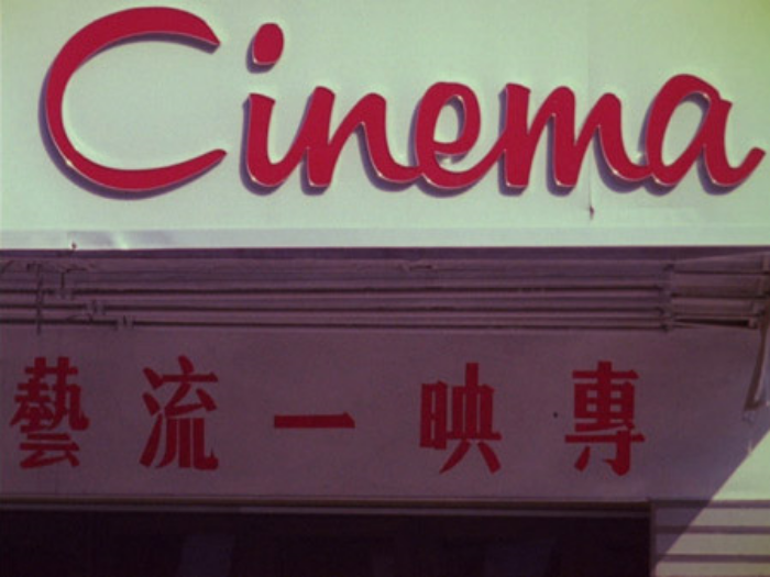 Signage reading Cinema in red script above Chinese characters on a building facade.