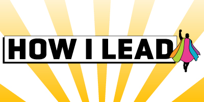 Graphic with bold text 'HOW I LEAD' in black on a white background with yellow rays. A silhouette wearing a rainbow-colored cape stands to the right, symbolizing leadership and empowerment.