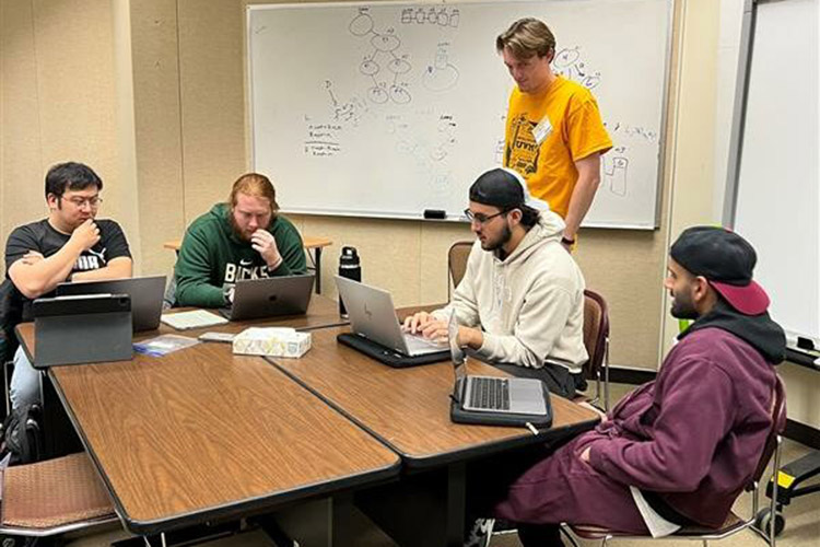 Group tutoring session at computers and whiteboard