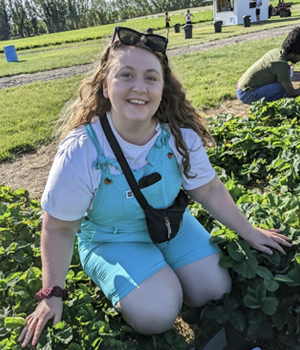 Nina Hartwig smiling while kneeling in a flowerbed.