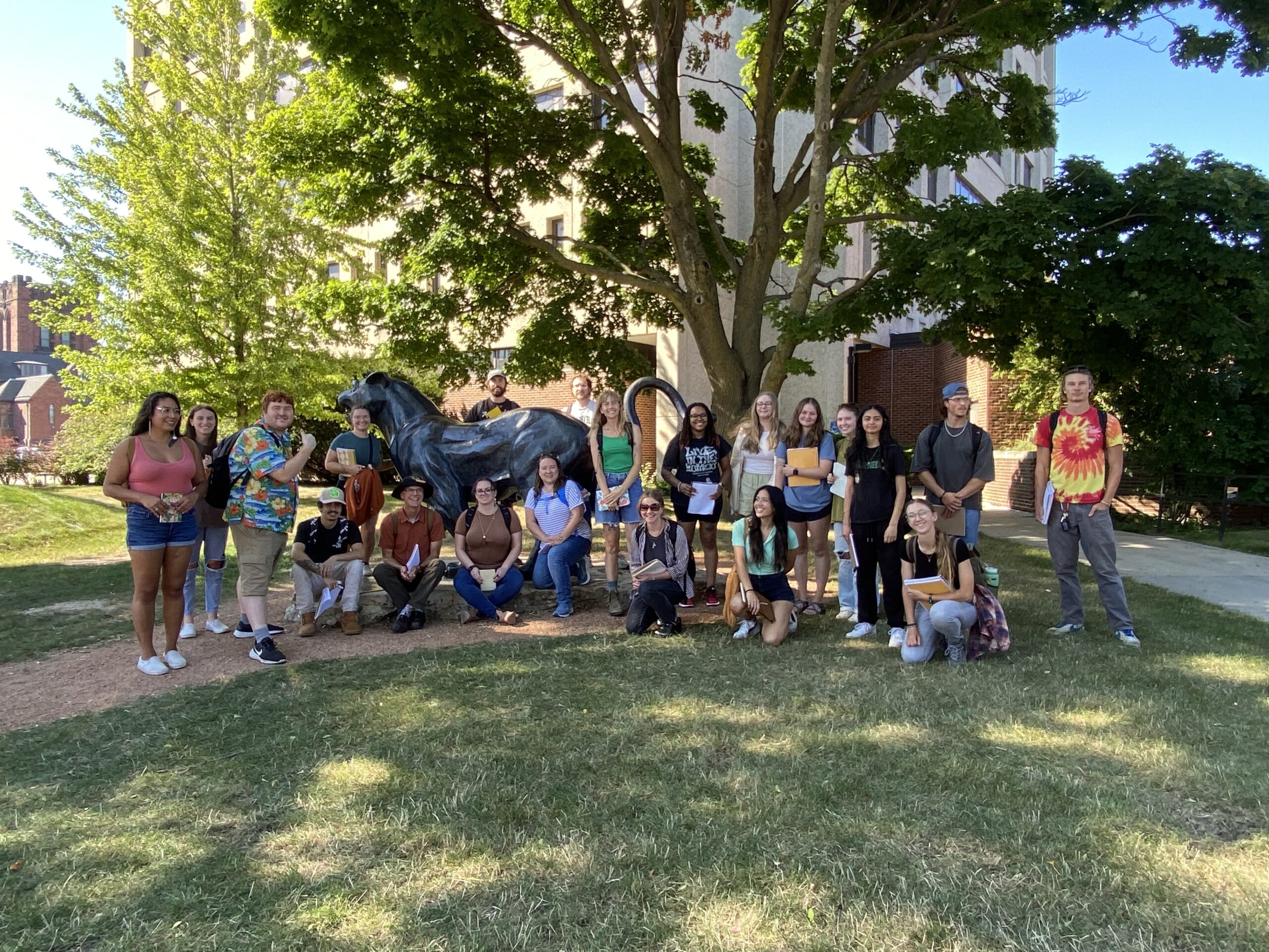 group of students on a tour gather at the Pounce Panther statue