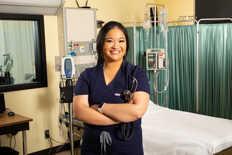 UWM Nursing student (asian woman) standing in a nursing clinical room