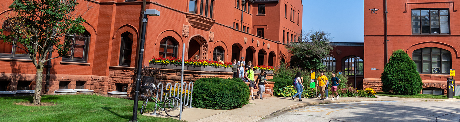 Students walking around the red brick buildings on UWM's campus