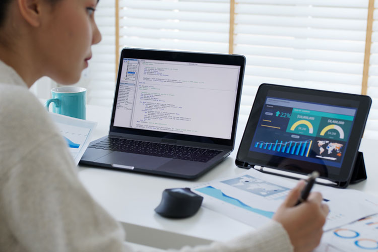 person using laptop and tablet