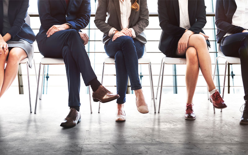 professionally dressed people in chairs