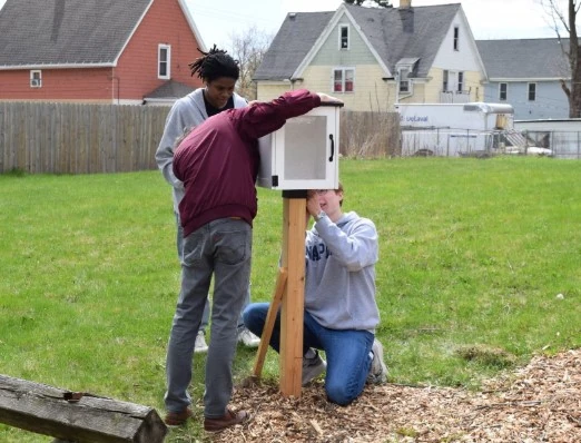 a group of people putting up a wooden post