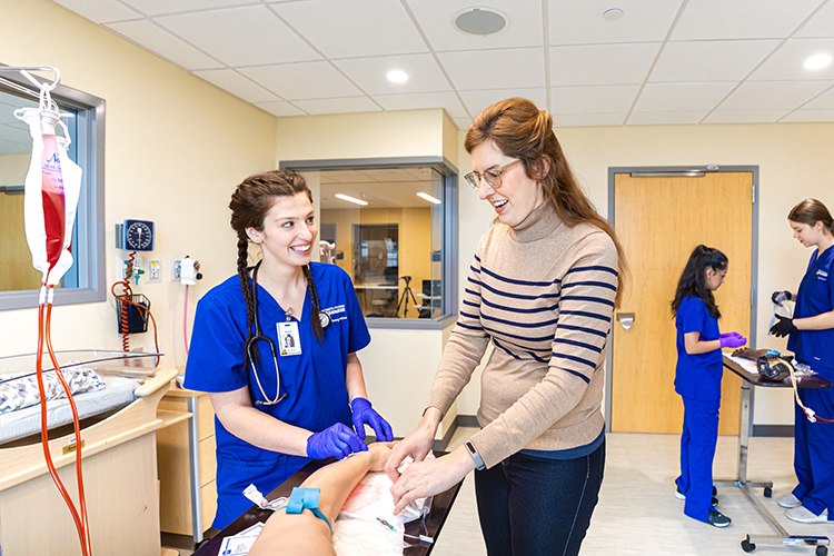 UWM at Waukesha Nursing student working with her instructor in the simulation lab.