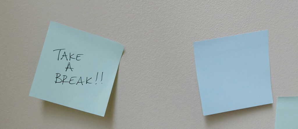 Blue sticky notes stuck to a wall, one reads "take a break!!" in handwritting