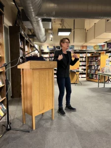 Speaker presenting at a bookstore podium during a book launch event