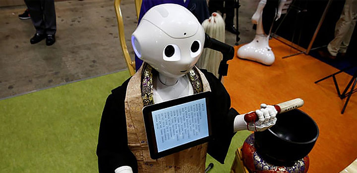 Humanoid robot holding a tablet and ceremonial object, dressed in traditional attire