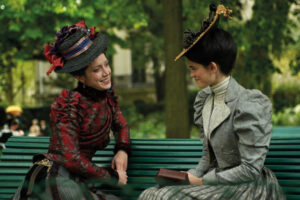 two people sitting on a park bench in old-fashioned clothing
