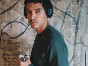 person with headphones on and holding a recorder