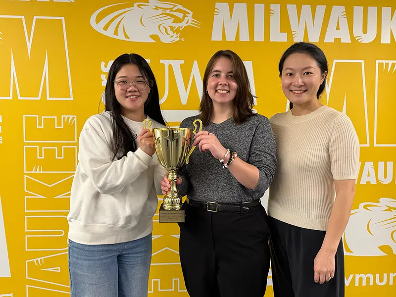 Awardees Isabelle Bright and Genevieve Dwyer with mentor Lu Yin, proudly displaying the national trophy earned by the UWM Chinese Program.