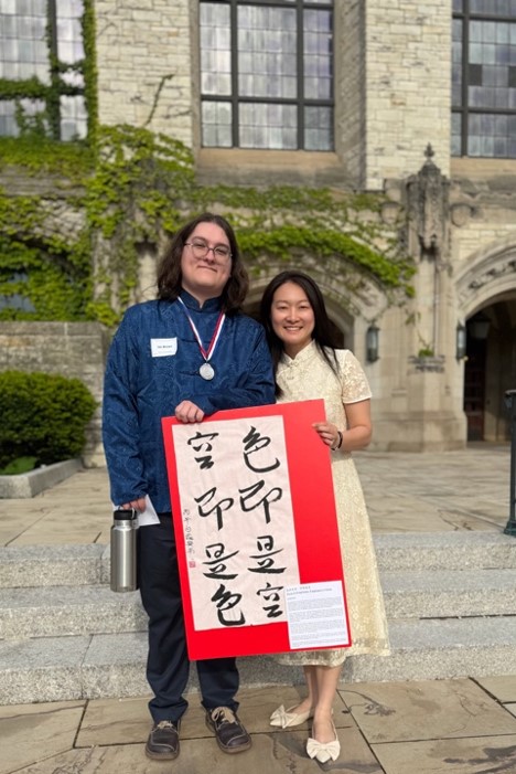 Silver medalists Ian Brown proudly presents his calligraphy piece alongside with his mentor, Lu Yin