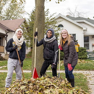 Students raking leaves in the neighborhood near UWM