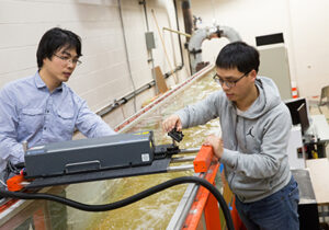Two students using engineering equipment