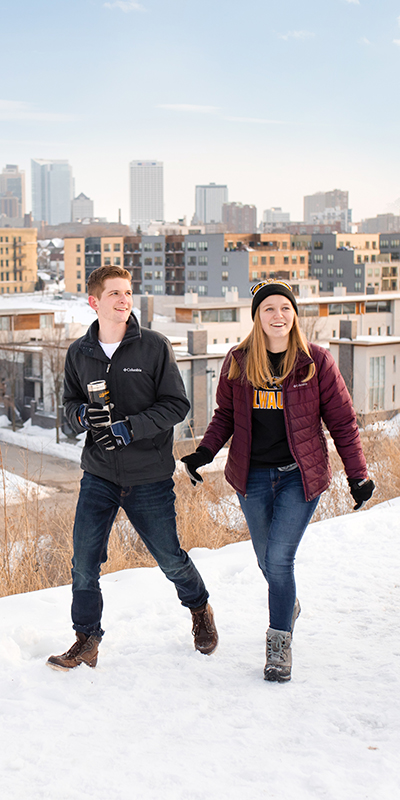 Students walking around in winter with the Milwaukee skyline in the background