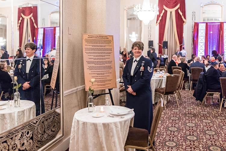 Kimberly Stuart, U.S. Air Force veteran and Wisconsin Air National Guard retiree, stands next to the Missing Man Table.