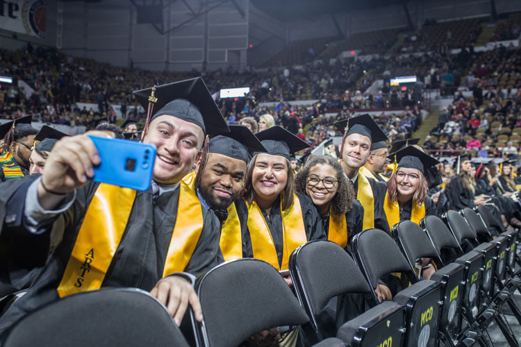 Students taking a selfie together at graduation