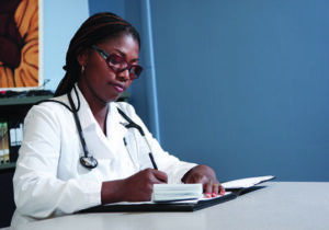 Doctor in white lab coat writing something down