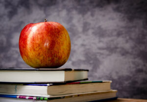 A short stack of books with an apple on top