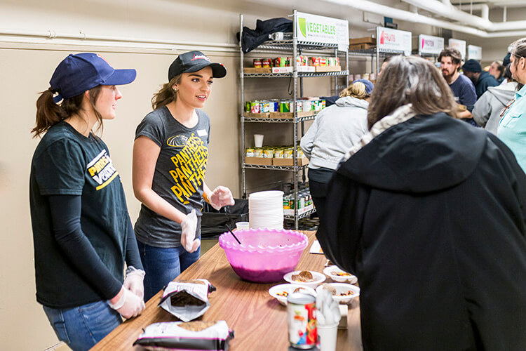 Cassie Ewig and Lisa Hren handing out samples at the Riverwest Food Pantry