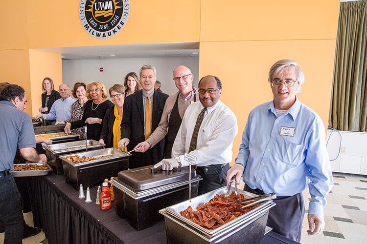 Chancellor Mark Mone (center) and other UWM leaders dish out food at the Serving Those Who Served Military and Veterans Brunch.