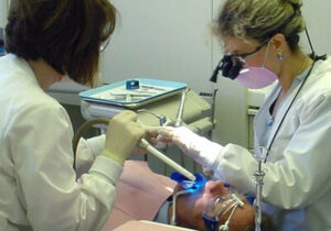 Dental student and instructor examining patient mouth