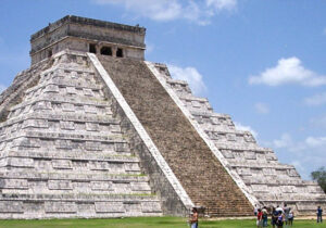 Mesoamerican pyramid with tourists standing at bottom