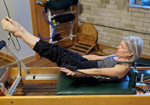Woman on pilates equipment and wearing workout gear